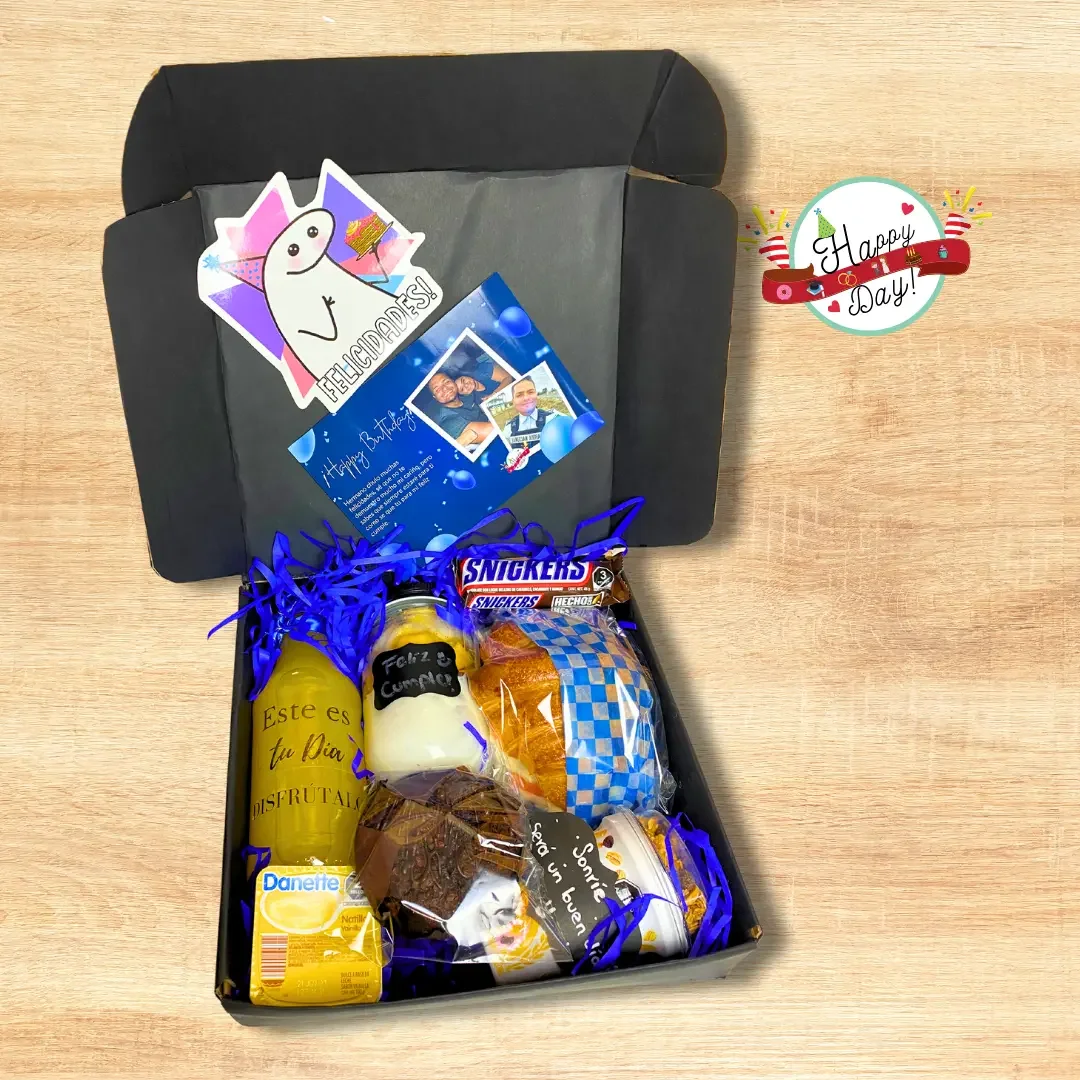 Caja negra abierta con cuernito, mix frutal, muffin, natilla, yogurt, jugo, chocolate y tarjeta personalizada.